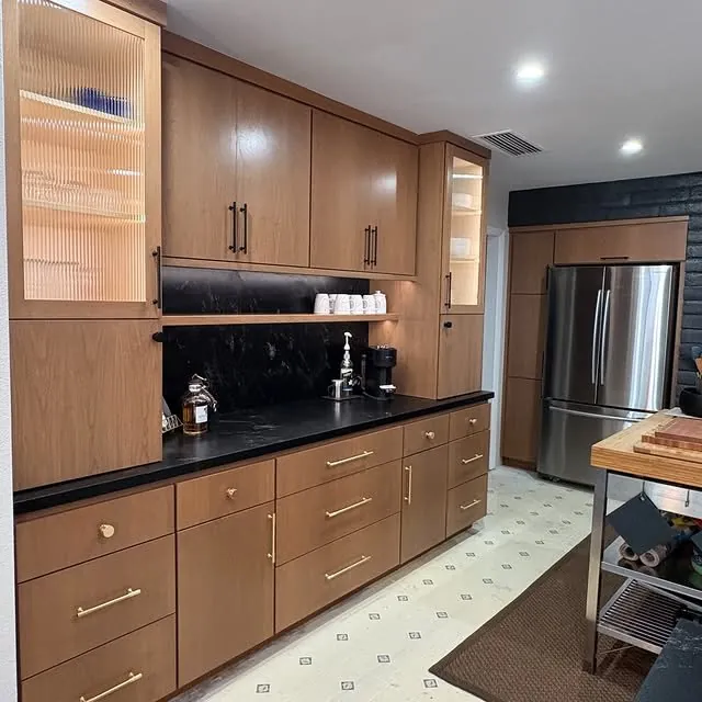 Pecan wall cabinets and a tall pantry next to the refrigerator