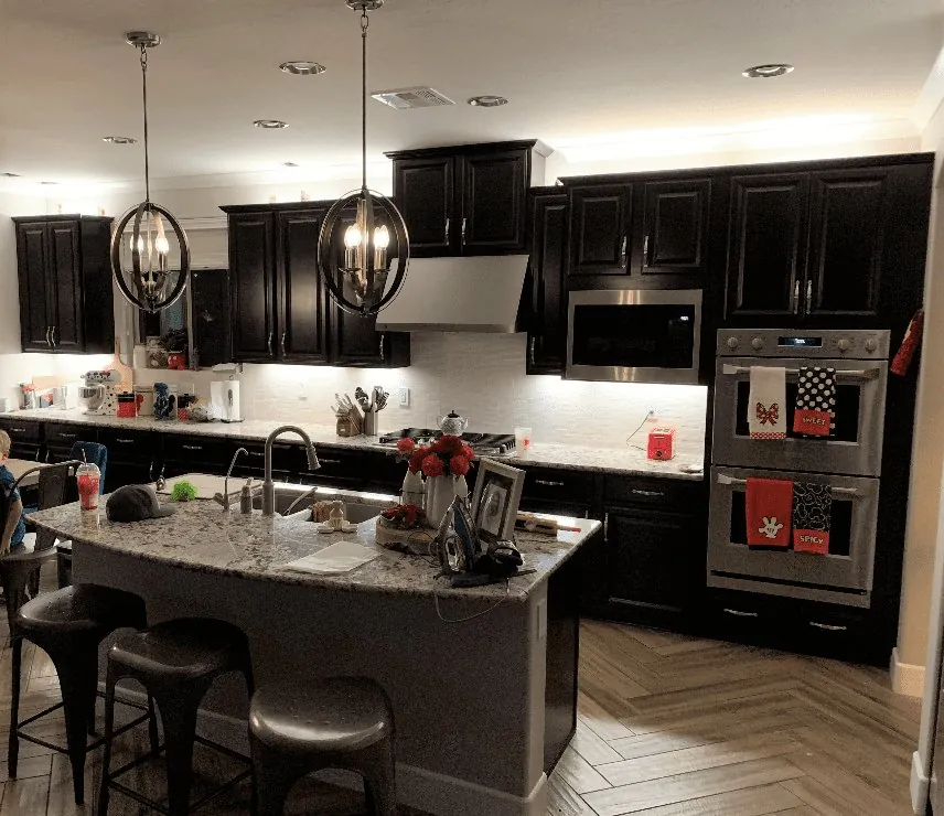 The kitchen before: dark cabinets and a granite island