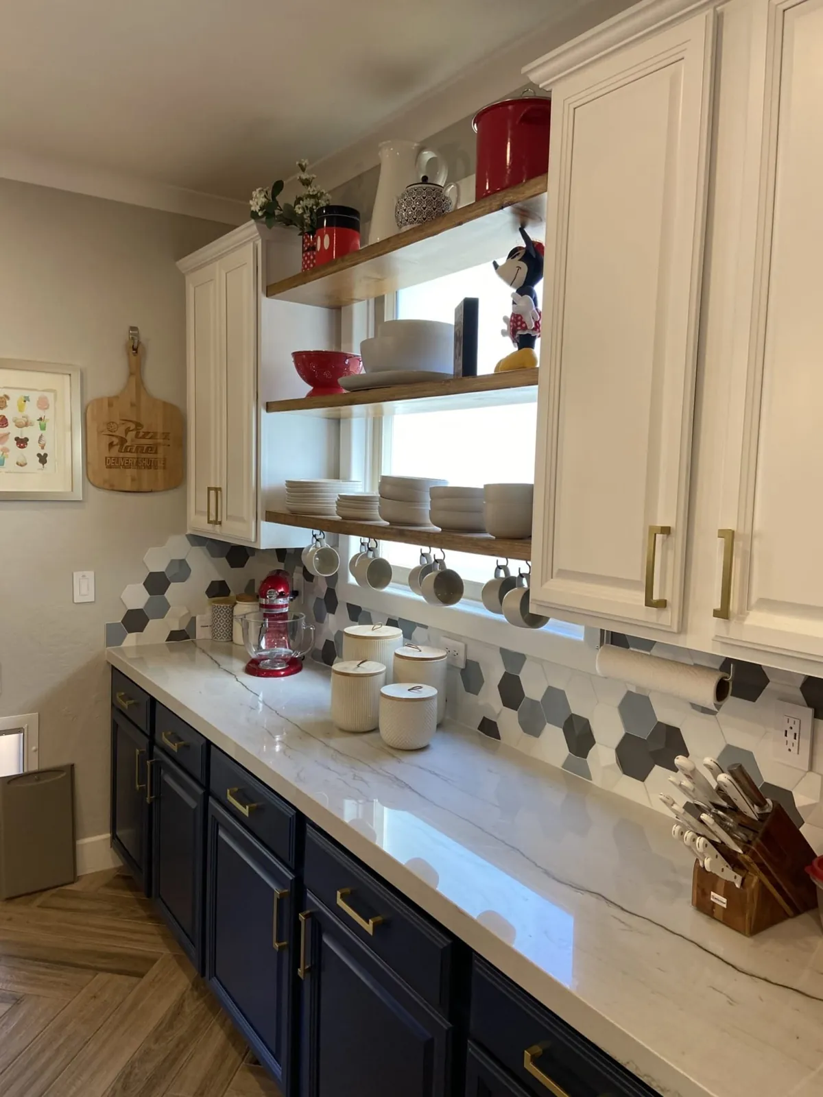 Open shelving and white uppers above the navy cabinet run