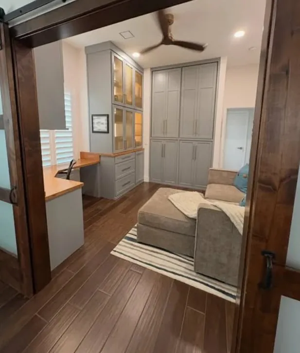 The office seen through walnut-framed glass doors