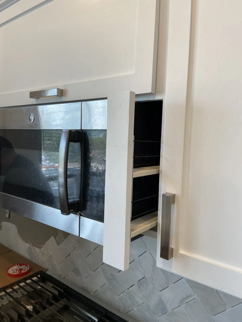 A narrow pull-out spice cabinet hidden beside the wall oven