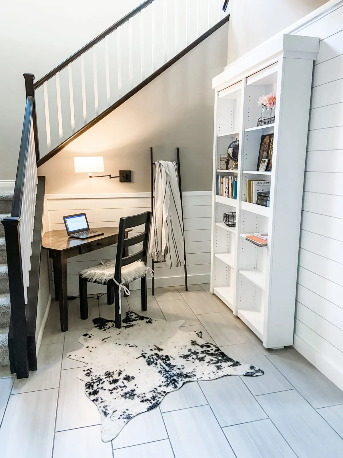 The study nook with a laptop on the desk and the bookcase beside it