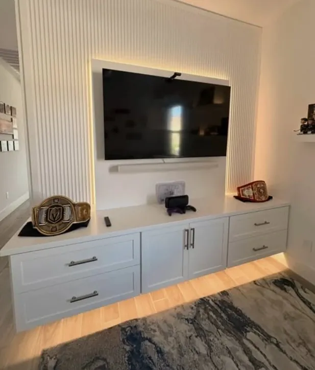 Fluted media wall with a floating cabinet and warm LED light underneath